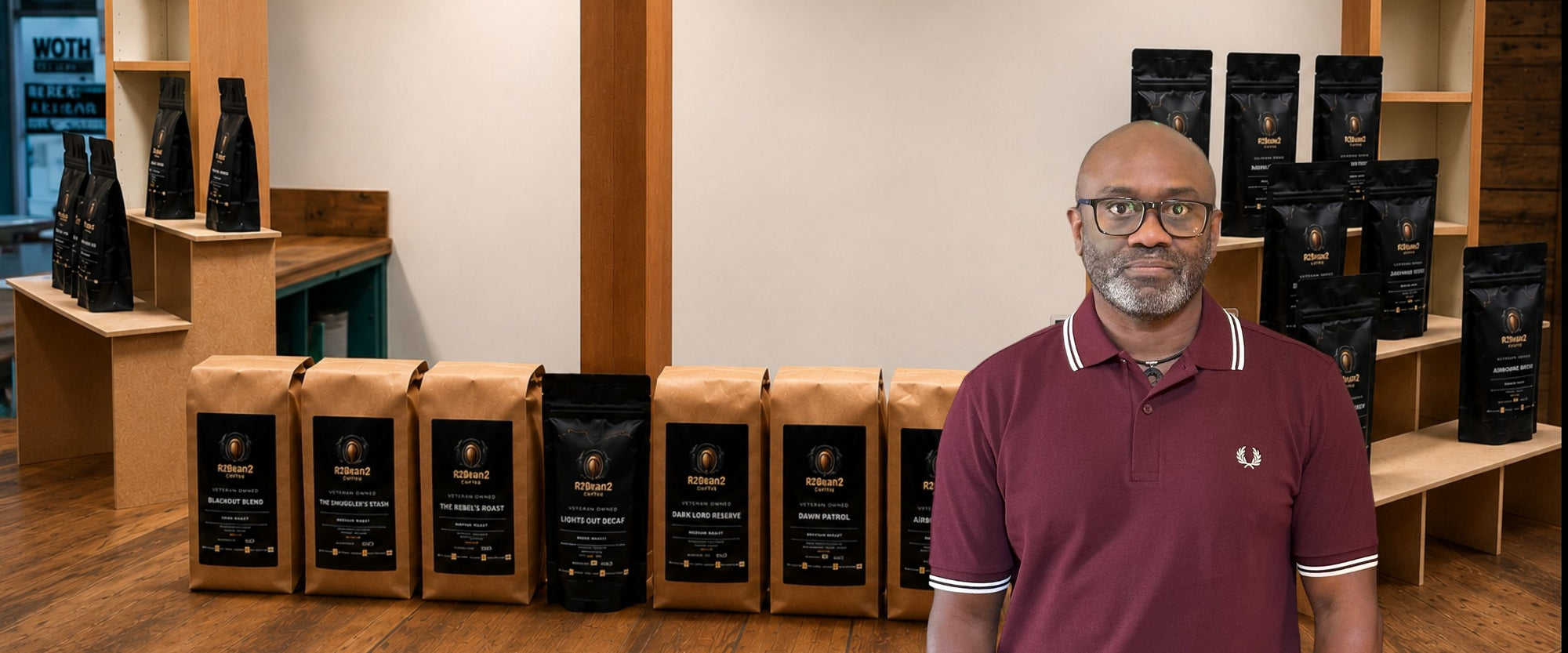 Rohan, founder of R2Bean2 Coffee, with bags of veteran-owned specialty coffee roasted in the UK.